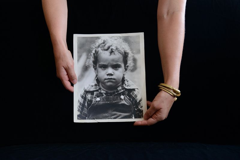 © Alice Proujansky - I hold a photograph of myself taken by family friend Anna Morrison in 1981.