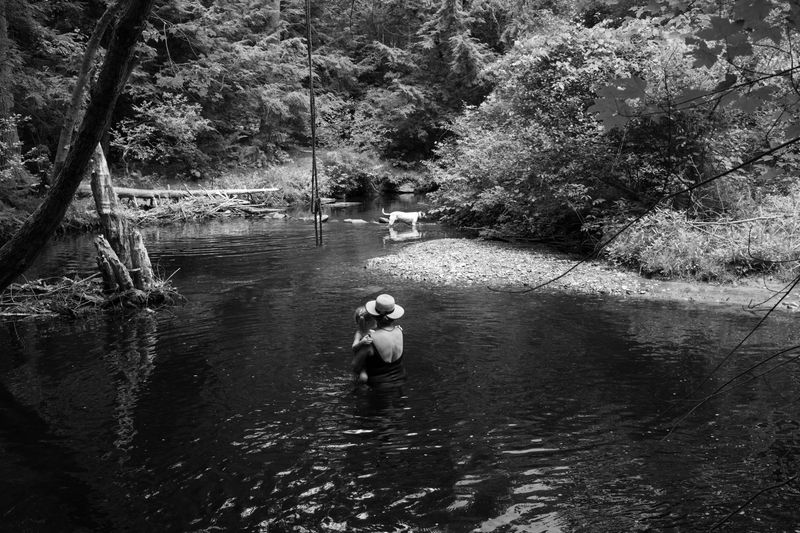 © Alice Proujansky - My mom, holds my daughter in a stream near my parents' home. Leverett, MA, 2019