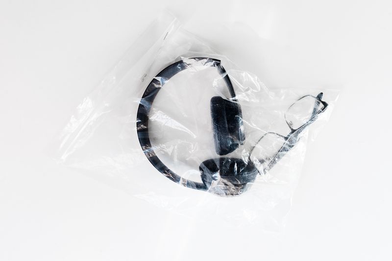 © Anna Galí - Earphones and glasses in a plastic bag.