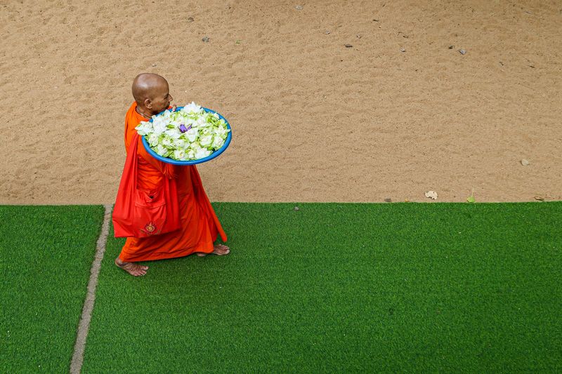 © Stefanos Chronis - Flowers offerings to Buddha from a nun at Anuradhapura Sacred City, Srilanka. Religion Theravada Buddhism