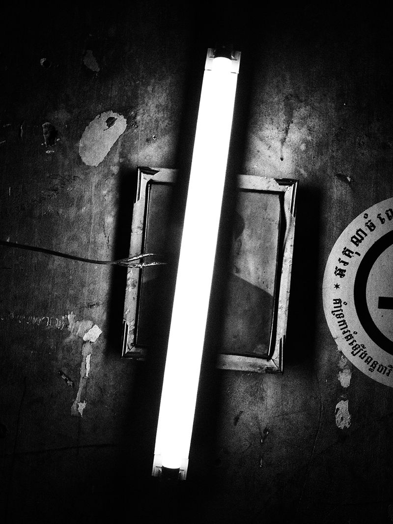 © Toni Arnau - Portrait of a family member hanging on the wall of an apartment in the center of the city. Phnom Penh, Cambodia, 2017.