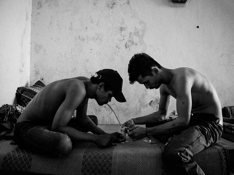 © Toni Arnau - Yark and Seiha, 27, smoke Ice in an old apartment in the center of the capital. Phnom Penh, Cambodia, 2017.