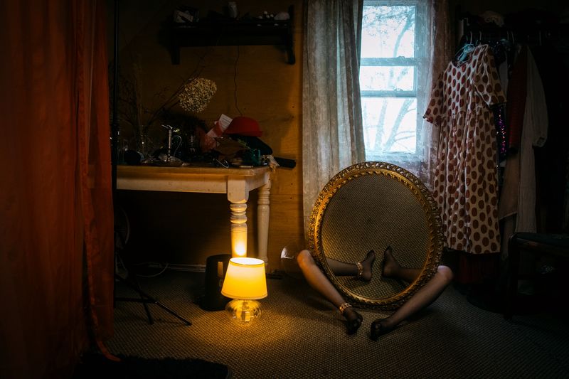 © Mari Saxon - Hiding inside myself (A mirror conceals the young woman, reflecting only the empty floor.)