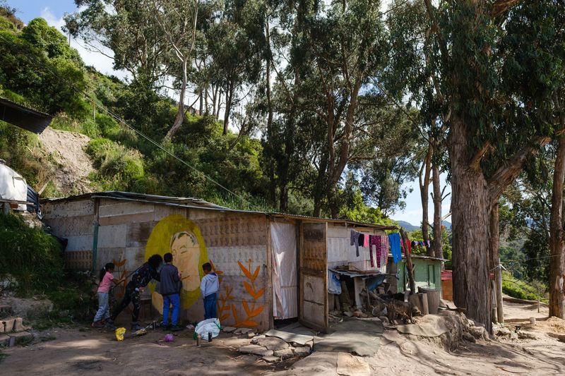 © Ana Vallejo - @negritamambo paints a house with the help of the children who live there.