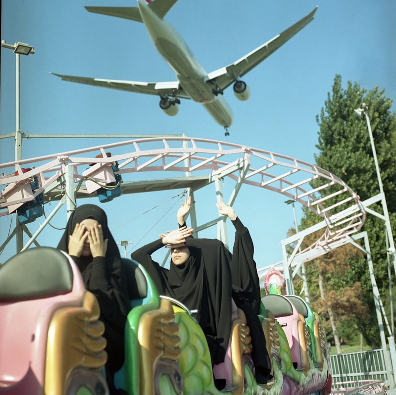 © Sabiha Çimen - Funfair. Turkey-Istanbul On the weekend girls are on the train at the fun fair and low-level plane passing by.
