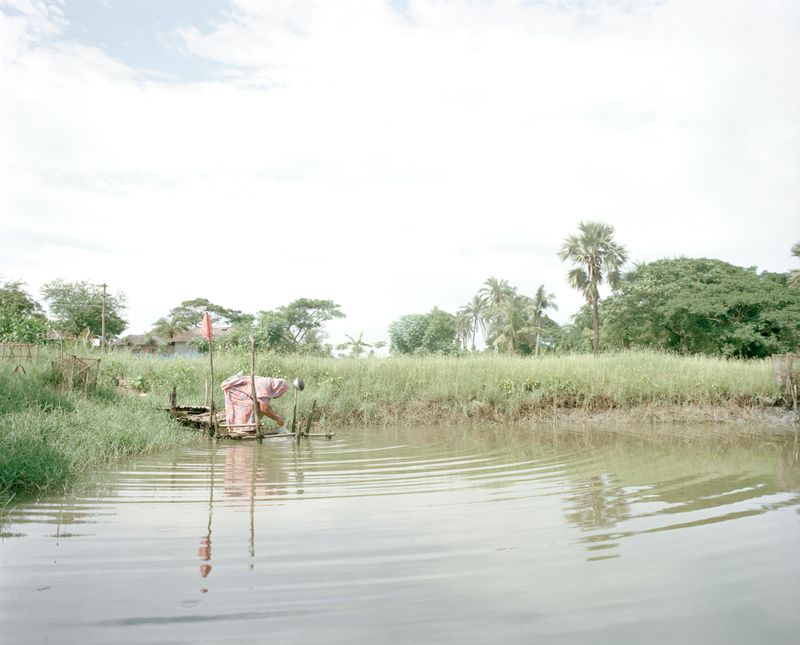 © Shunta Kimura - A woman is doing the washing with the water pond.