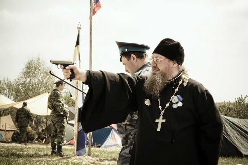 © Denis Tarasov - A priest of the Russian Orthodox Church firing a hand gun. Sverdlovsk region, Russia.