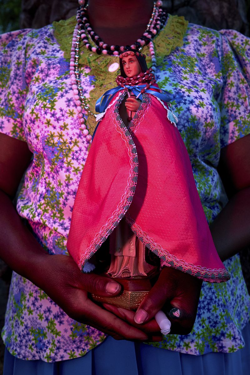 © Johanna Alarcón - A woman carrying a statue of the Virgin of Mercy during a pilgrimage of Catholic and African ancestral rituals. Quito,2019.