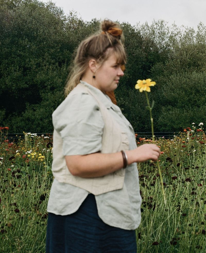© Hayleigh Longman - Ffion in front of huge bed of dye flowers growing on land. 2025