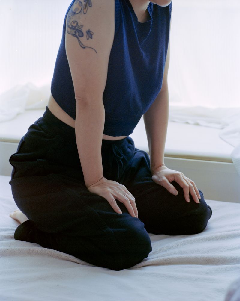 © Tianxi Wang - Girl with a Bee Tattoo, Kneeling on the Bed