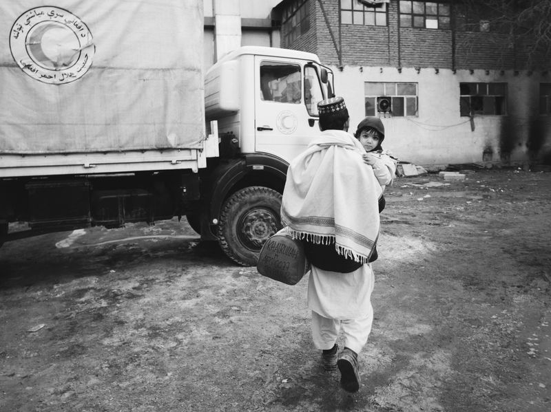 © Toby Binder - A father leaves the Red Crescent compound with his healed child.