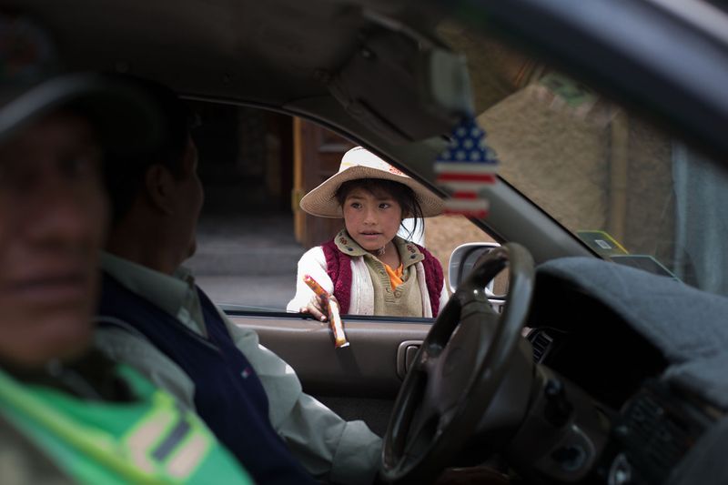 © Toby Binder - Girl selling sweets to people passing by in their cars.