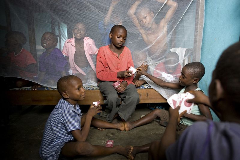 © Toby Binder - Abraham, 8, Israel Ekpa, 12 and Godwin, 9 playing cards in one of the dormitories of the Centre.