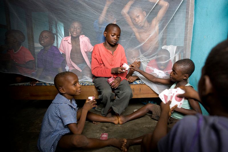 © Toby Binder - Abraham, 8, Israel Ekpa, 12 and Godwin, 9 playing cards in one of the dormitories of the Centre.