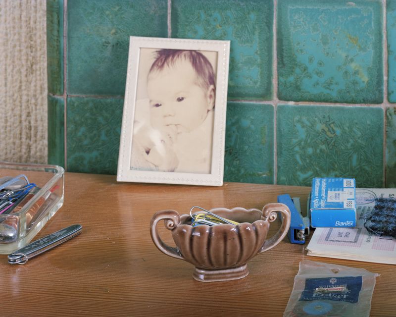 © Oliver Woods - My old desk that dad had been using. In the middle is a framed fading photo of my baby sister Caroline.