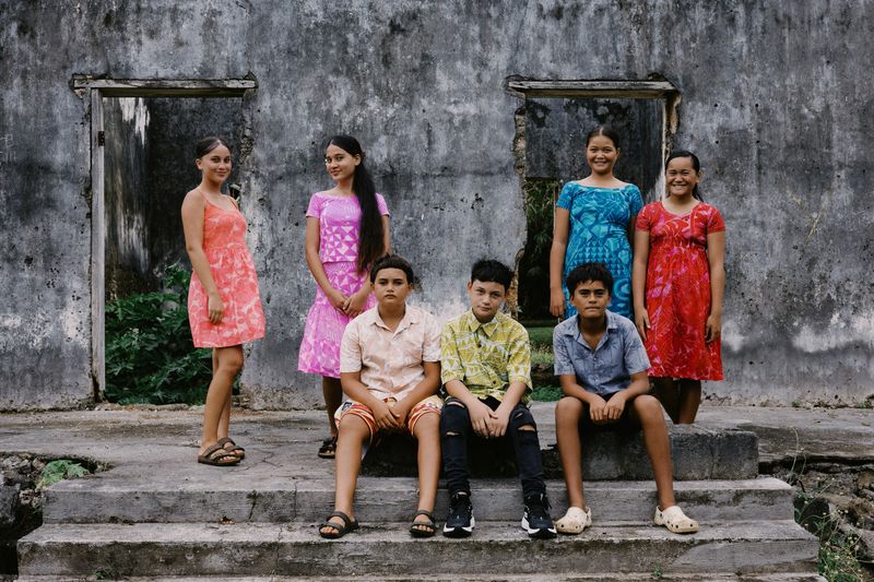 © Raquel Trejo - Coral Kids infront of traditional homes made out of coral