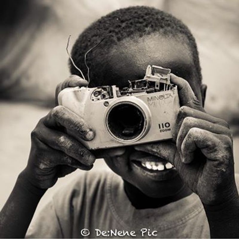 © Dennis Munene - A Dinka boy trying to take a picture on me photographing him.