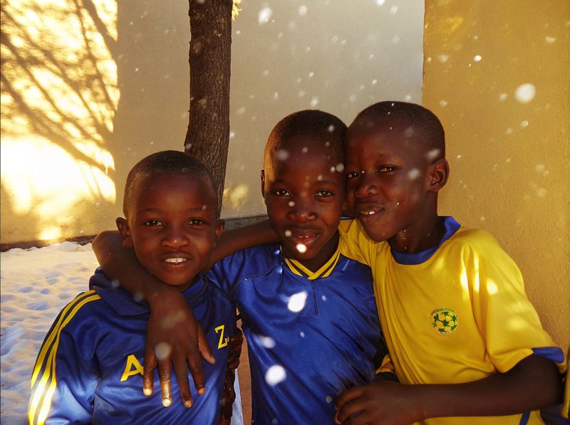 © yingying gao - August 2023, Dar es Salaam. Three close friends playing a game.