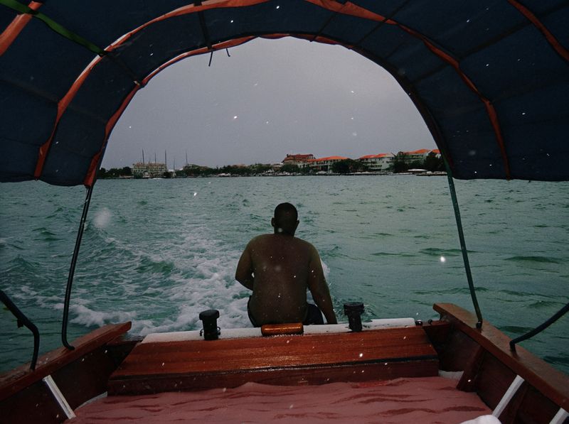 © yingying gao - August 2023, Dar es Salaam. A fisherman steering his boat on the ocean.