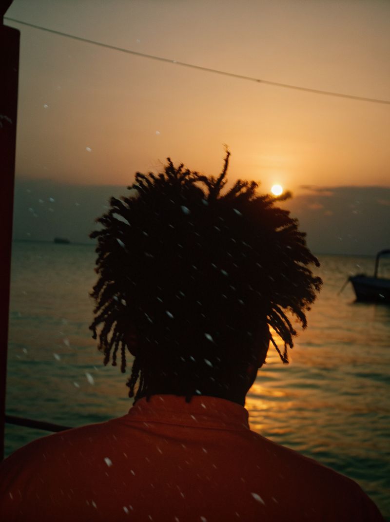 © yingying gao - August 2023, Dar es Salaam. A man watching the sunset by the sea.