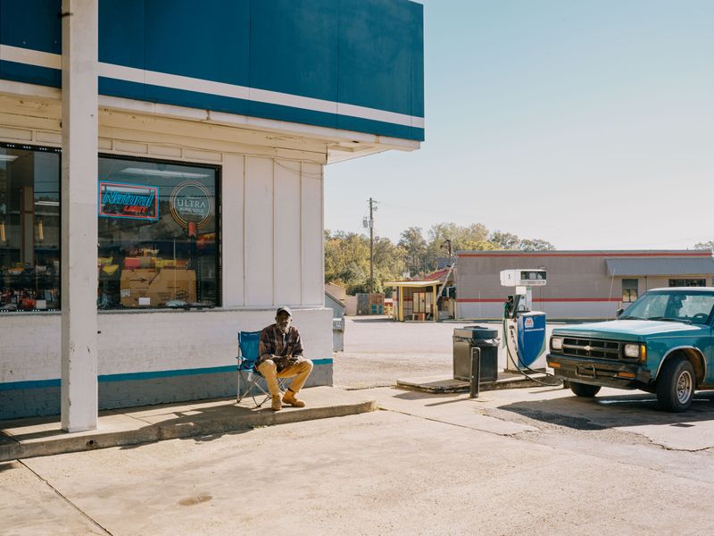 © Jorge Dieguez - A man relaxing outside a petrol station in Ewta, Alabama.