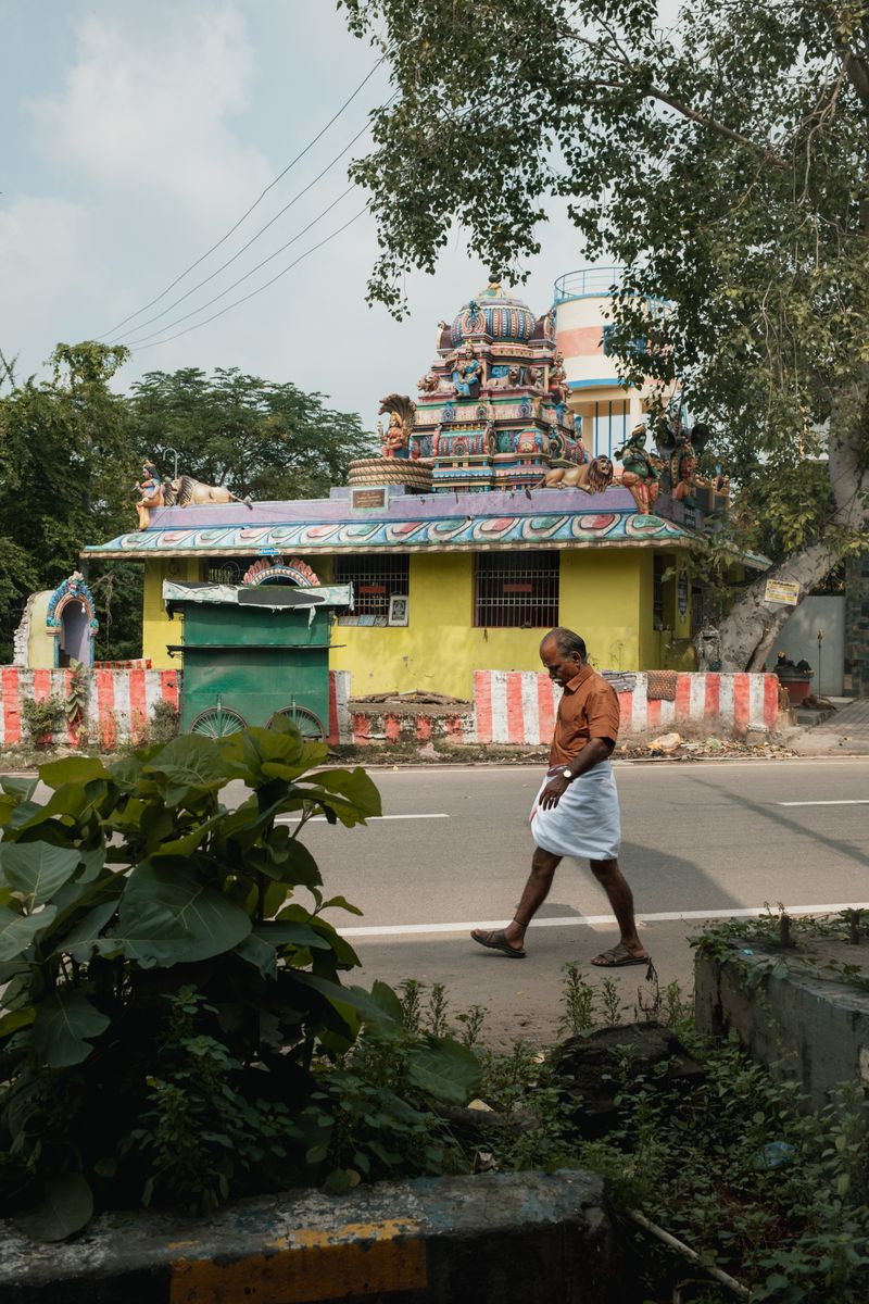 © Yvonne Chu - Roadside temple, a man walking past; faith and commuting share the same lane.