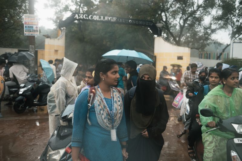 © Yvonne Chu - Outside the college gate, two figures hold distance; waiting becomes choreography.