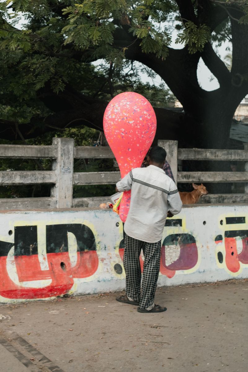 © Yvonne Chu - A balloon pauses mid-crossing; play interrupts the city’s hard tempo for a moment.