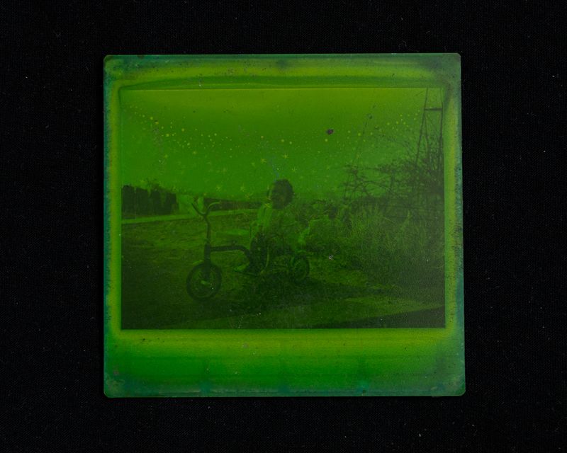 © Andrea Sarcos - A deteriorated polaroid that turned green after time and water damage from the flood. Venezuela, 2023.