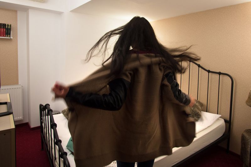 © Stefano Schirato - C. 21, enters the room of Happy Studio and take off her coat before starting her eight hours of webcam session.