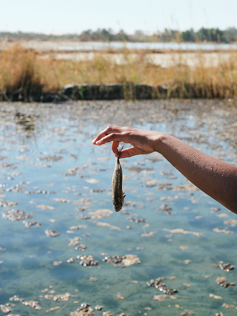 © Nathalie Mohadjer - Mohammad holding a dead fish at a cold spring.