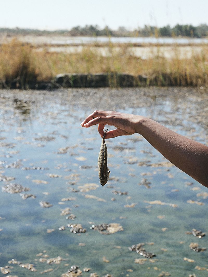 © Nathalie Mohadjer - Mohammad holding a dead fish at a cold spring.