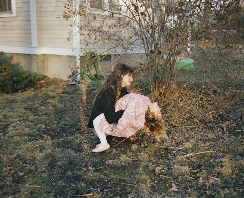 © Jo Ann Walters - 13_mother lifting daughter in pink coat, from the series Vanity + Consolations, 1988-present