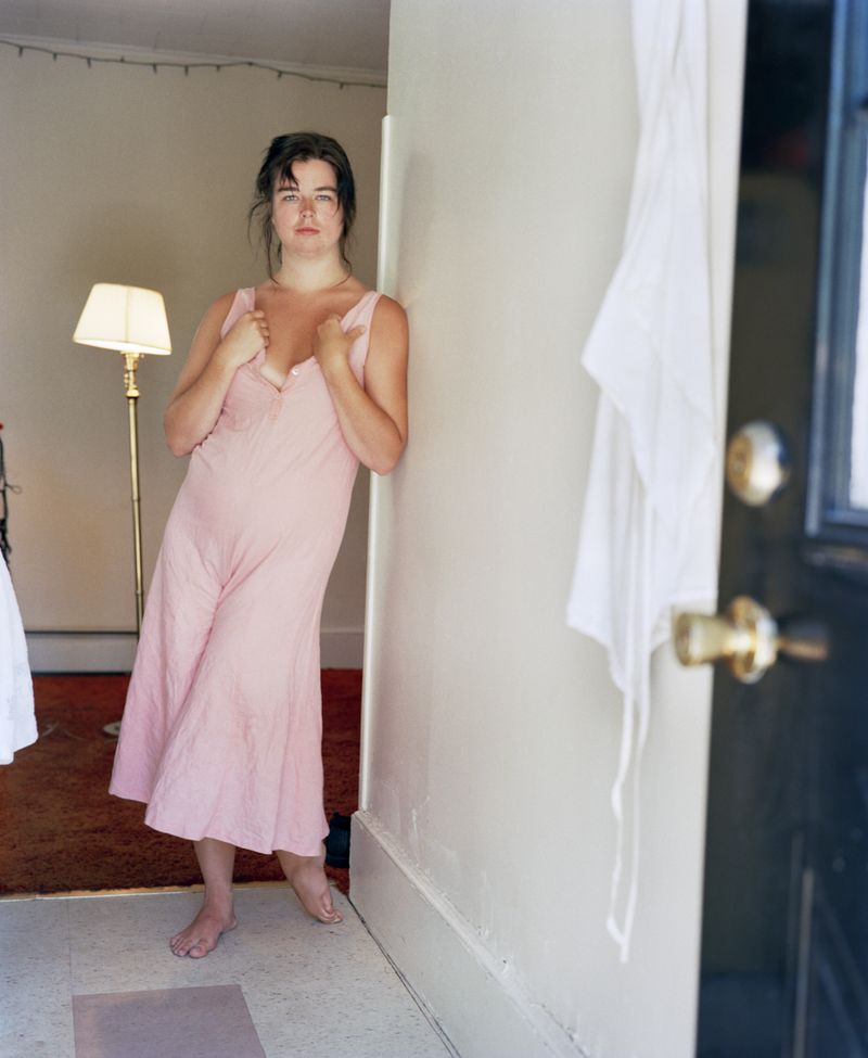 © Jo Ann Walters - 18_young woman in pink dress w lamp in doorway, from the series Vanity + Consolation, 1988-present