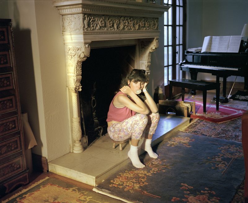 © Jo Ann Walters - 19_Andra sitting near fireplace blowing bubble, from the series Vanity + Consolation, 1988-present