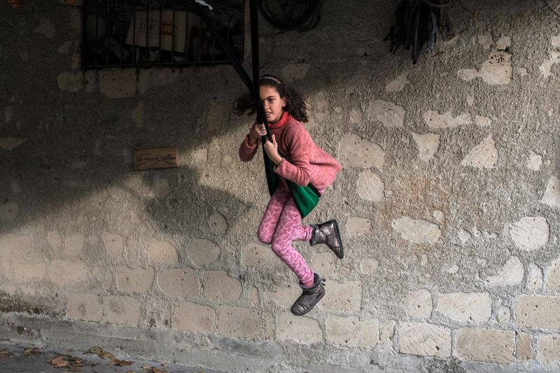 © Claire Power - A girl plays on a swing in her father's garden