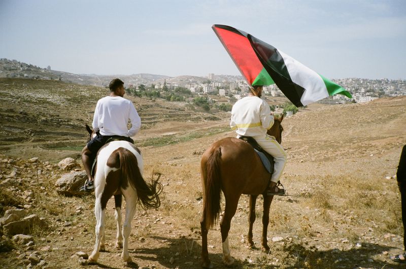 © Melissa COLLETT - Taha and Ihab riding their horses in with the flag of Palestine in Beit Sahour,