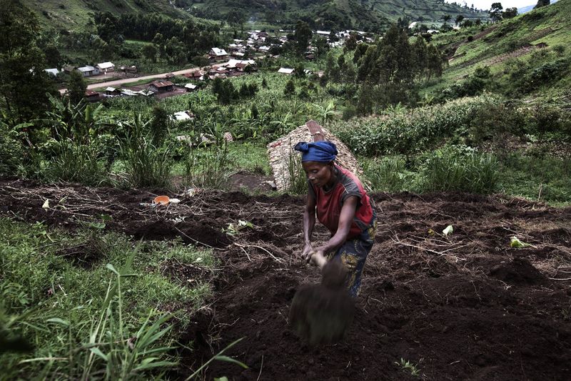 © Annibale Greco - A woman works in the fields of Buganga wih the village in the background, South Kivu province, DRC, 10 November 2011.