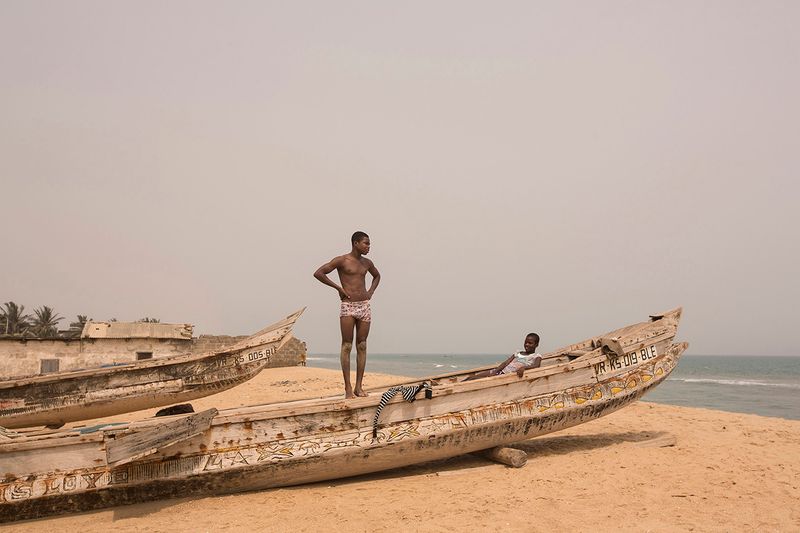 © Matilde Gattoni - Ghana - Blekusu - Young villagers stand on a traditional fishing boat.