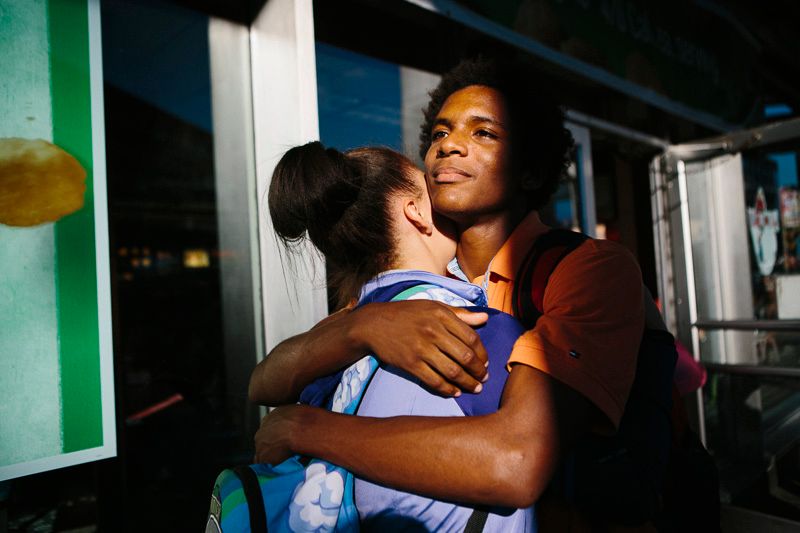 © Cassandra Giraldo - Two friends embrace on their way home after school in front of a McDonalds in Brooklyn on September 17, 2015.