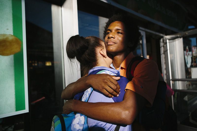 © Cassandra Giraldo - Two friends embrace on their way home after school in front of a McDonalds in Brooklyn on September 17, 2015.
