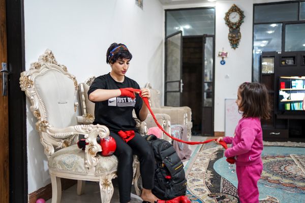 © Ali Rad - Hanieh is preparing for her boxing practice at home while her daughter watches her.