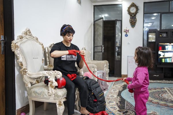 © Ali Rad - Hanieh is preparing for her boxing practice at home while her daughter watches her.