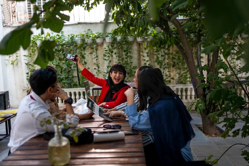 © Ali Rad - Hanieh and her friends are taking a photo together at a café.