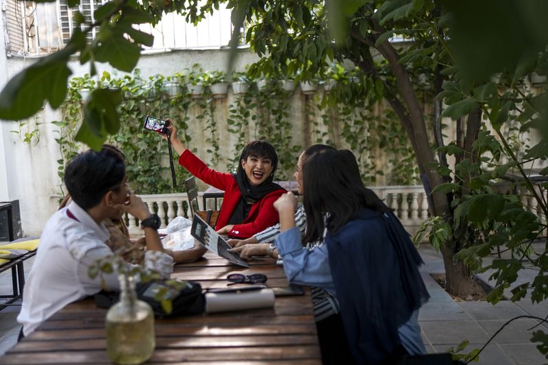 © Ali Rad - Hanieh and her friends are taking a photo together at a café.