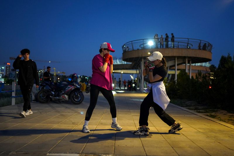 © Ali Rad - Hanieh trains boxing with her friend in the park.