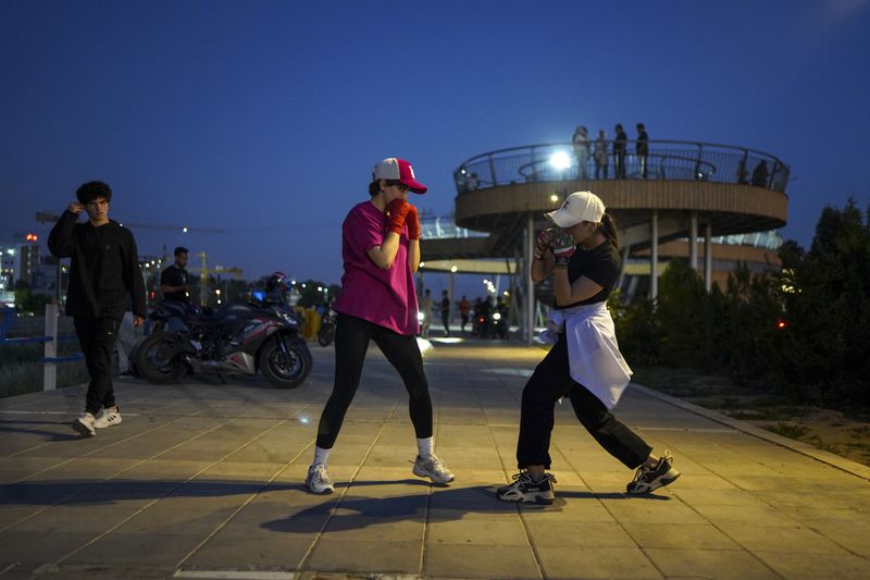 © Ali Rad - Hanieh trains boxing with her friend in the park.