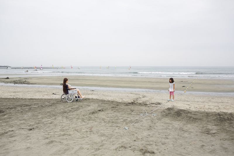 © Taro Karibe - A girl stares at Senji Nakajima's Love Doll 'Saori' at Zaimokuza beach on July 8, 2016 in Kanagawa, Japan.