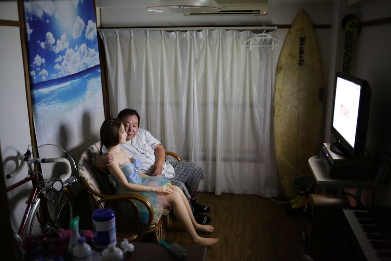 © Taro Karibe - Senji Nakajima watches TV with his Love Doll 'Saori' at his apartment on June 25, 2016 in Tokyo, Japan.