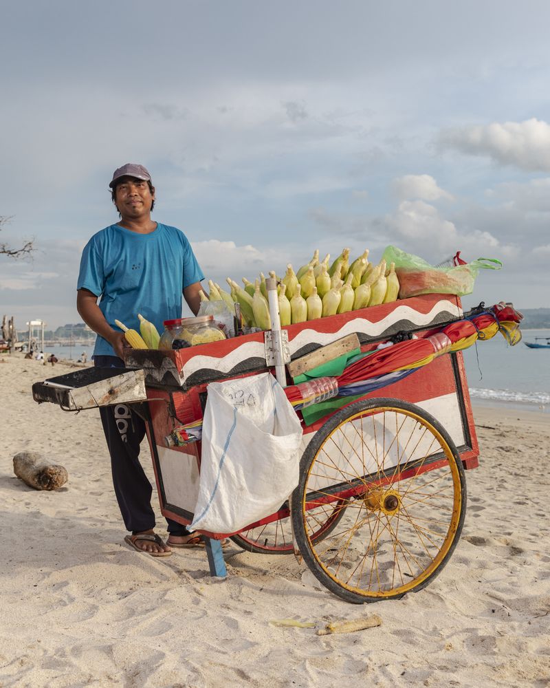 © Nyimas Laula - Lalu, 30, sells roasted corn and steamed peanuts at Kelan Beach in South Kuta, Bali.